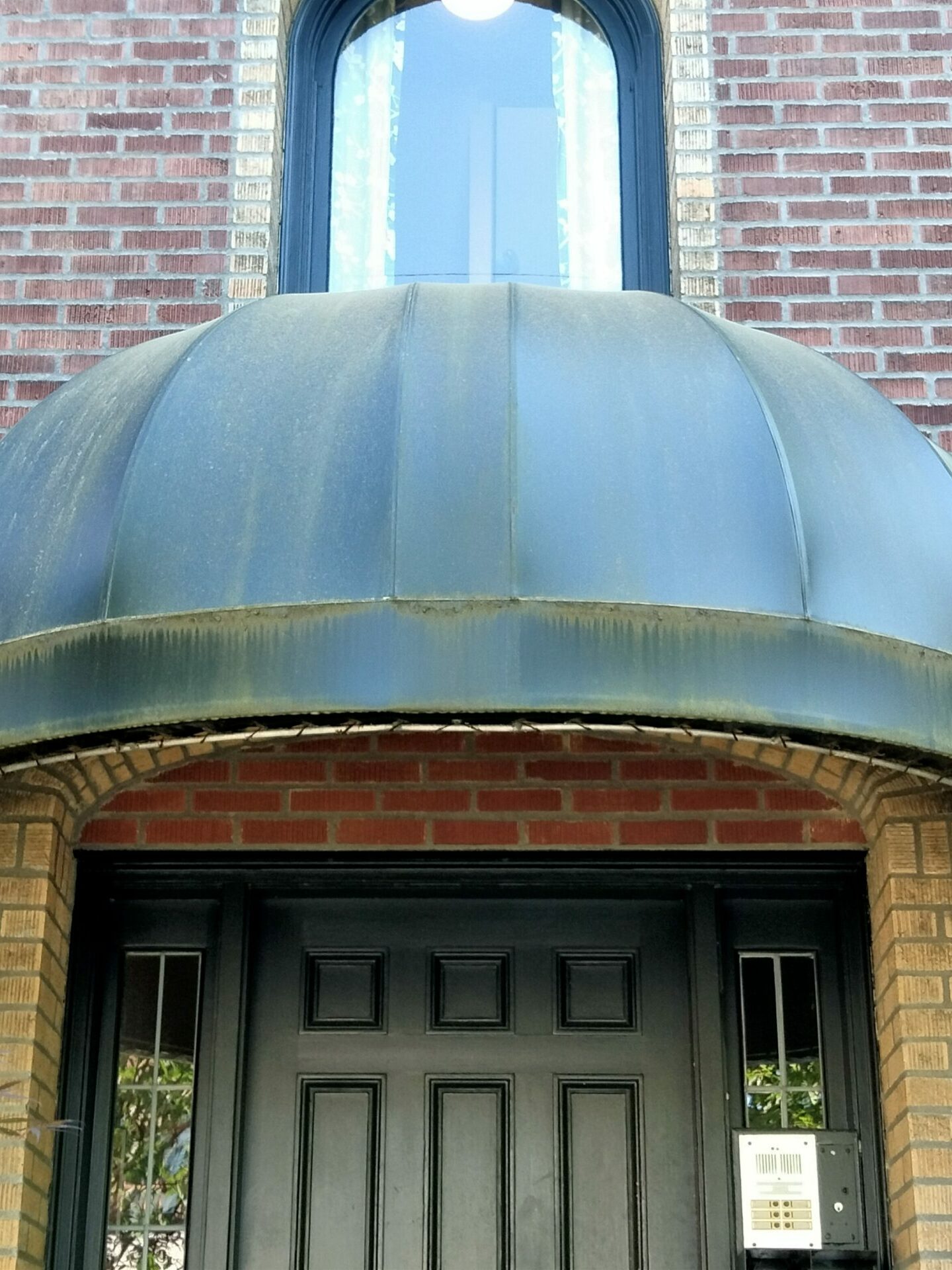 Picture of a green awning with moss and algae before awning pressure washing and awning cleaning