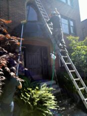 Image of a technician on a ladder performing awning cleaning