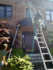 Image of a technician performing commercial awning cleaning for a fabric awning